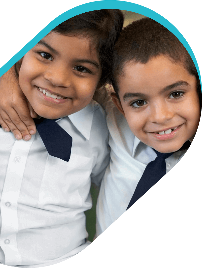 Two children in school uniforms posing for a picture.